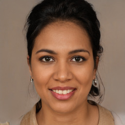 Joyful latino young-adult female with medium  brown hair and brown eyes