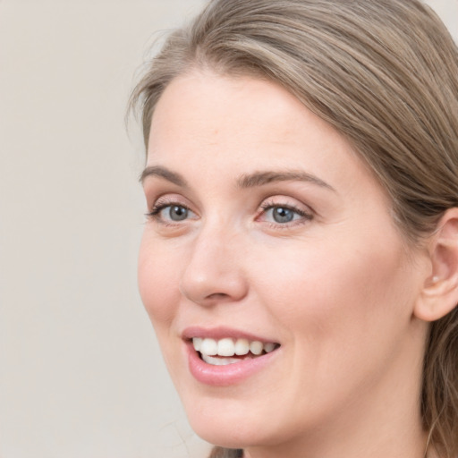 Joyful white young-adult female with long  brown hair and blue eyes