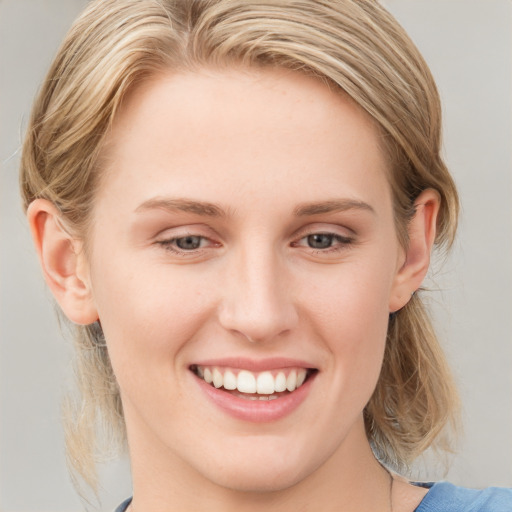 Joyful white young-adult female with medium  brown hair and blue eyes