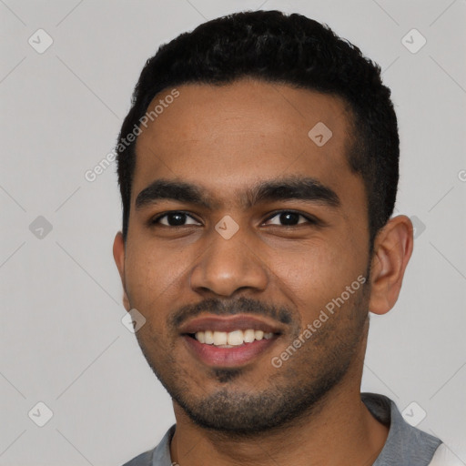 Joyful black young-adult male with short  black hair and brown eyes
