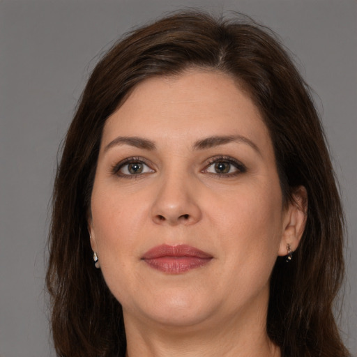 Joyful white adult female with long  brown hair and brown eyes