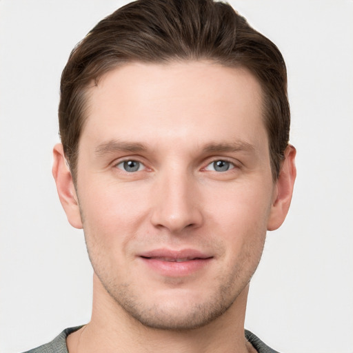 Joyful white young-adult male with short  brown hair and grey eyes