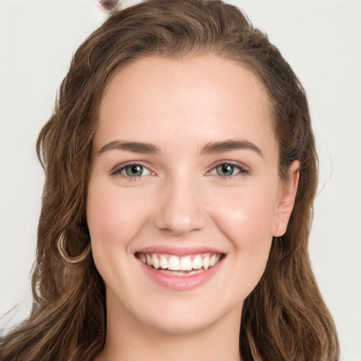 Joyful white young-adult female with long  brown hair and green eyes