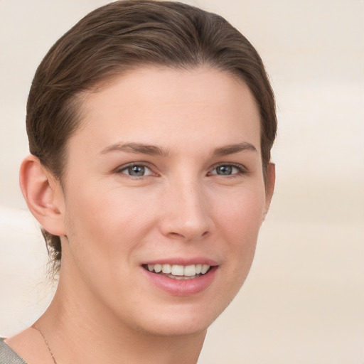 Joyful white young-adult female with short  brown hair and grey eyes