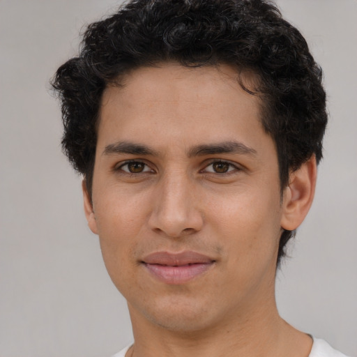 Joyful latino young-adult male with short  brown hair and brown eyes