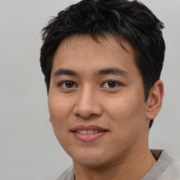 Joyful asian young-adult male with short  brown hair and brown eyes