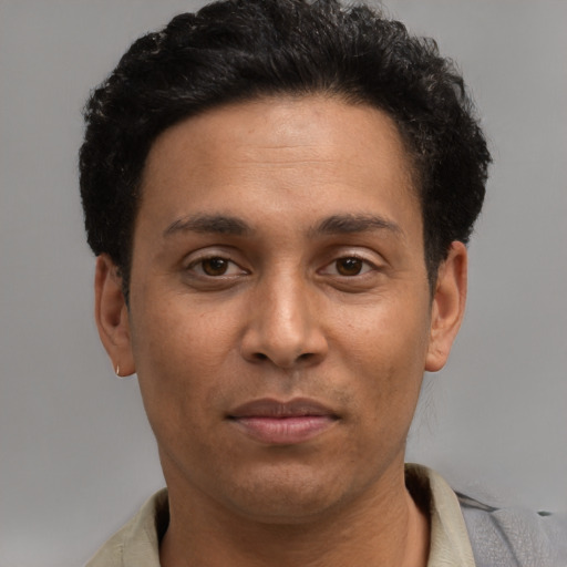 Joyful latino young-adult male with short  brown hair and brown eyes