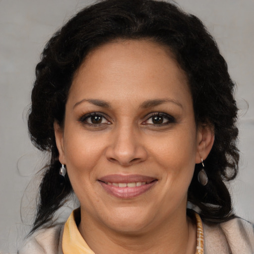 Joyful latino adult female with medium  brown hair and brown eyes