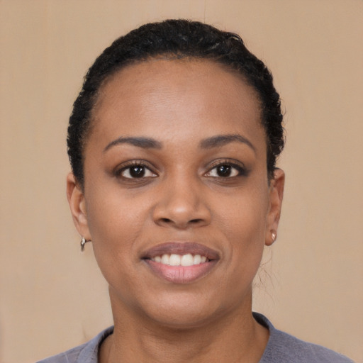 Joyful black young-adult female with short  black hair and brown eyes