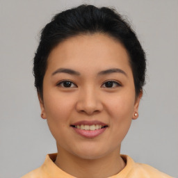 Joyful asian young-adult female with short  brown hair and brown eyes