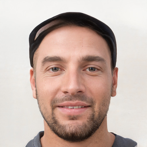 Joyful white young-adult male with short  black hair and brown eyes