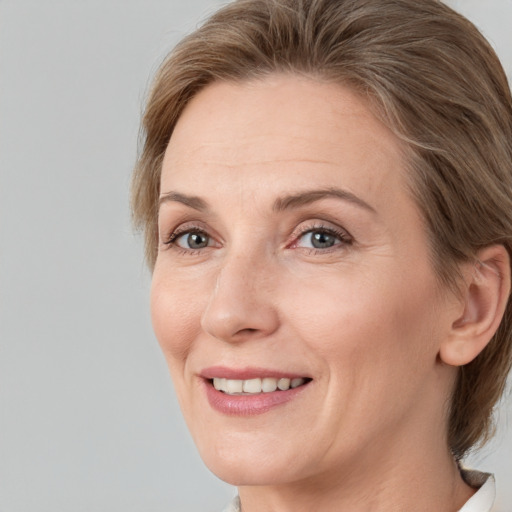 Joyful white adult female with medium  brown hair and grey eyes