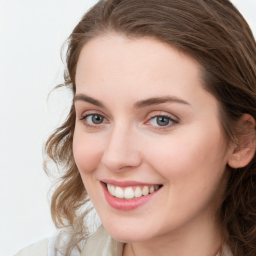 Joyful white young-adult female with long  brown hair and blue eyes