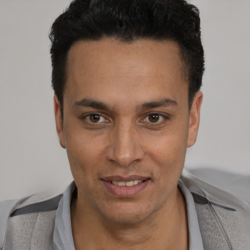 Joyful latino young-adult male with short  black hair and brown eyes