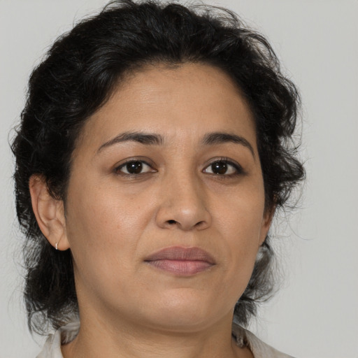 Joyful latino adult female with medium  brown hair and brown eyes