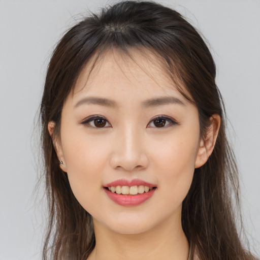 Joyful asian young-adult female with long  brown hair and brown eyes