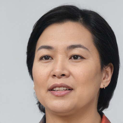 Joyful asian adult female with medium  black hair and brown eyes