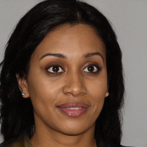 Joyful black young-adult female with long  brown hair and brown eyes