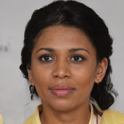 Joyful black adult female with medium  brown hair and brown eyes