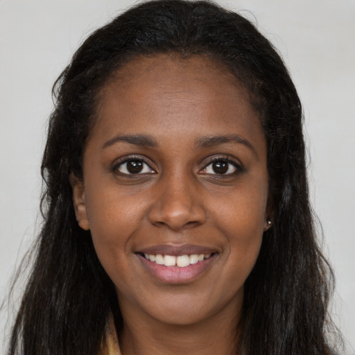 Joyful black young-adult female with long  brown hair and brown eyes