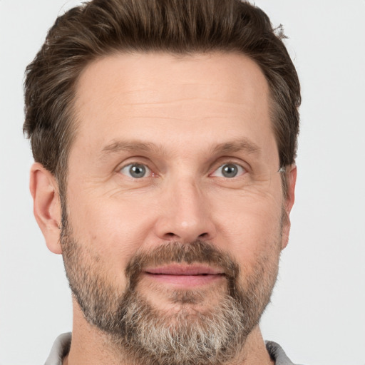 Joyful white adult male with short  brown hair and grey eyes