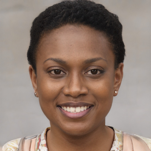 Joyful black young-adult female with short  black hair and brown eyes