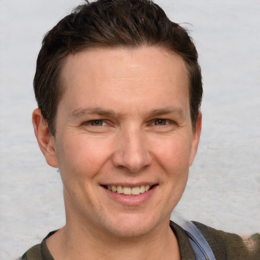 Joyful white adult male with short  brown hair and grey eyes