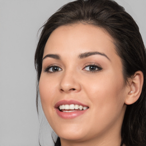 Joyful white young-adult female with long  brown hair and brown eyes