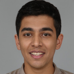 Joyful latino young-adult male with short  black hair and brown eyes