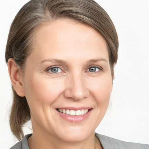 Joyful white adult female with medium  brown hair and grey eyes