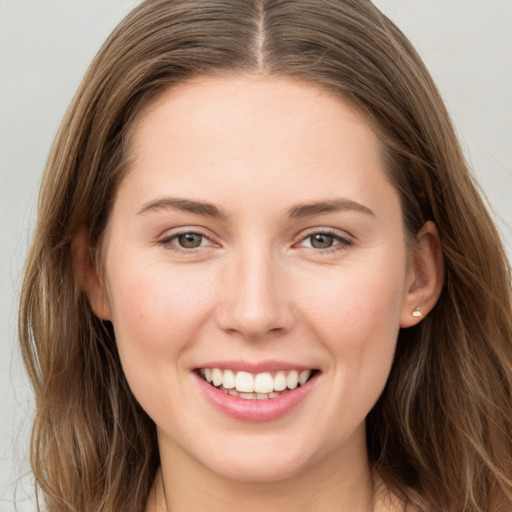 Joyful white young-adult female with long  brown hair and grey eyes