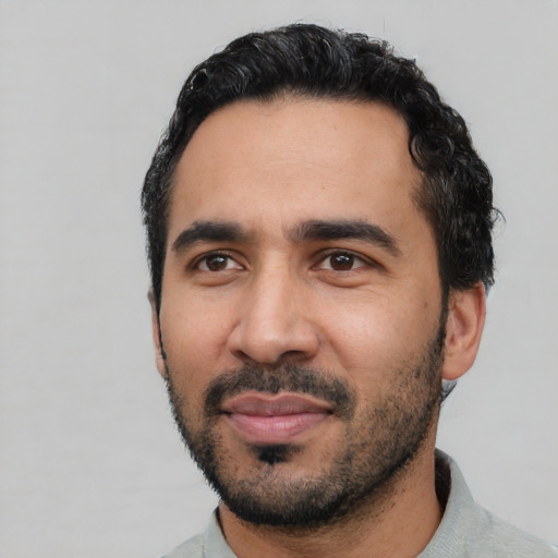 Joyful latino young-adult male with short  black hair and brown eyes