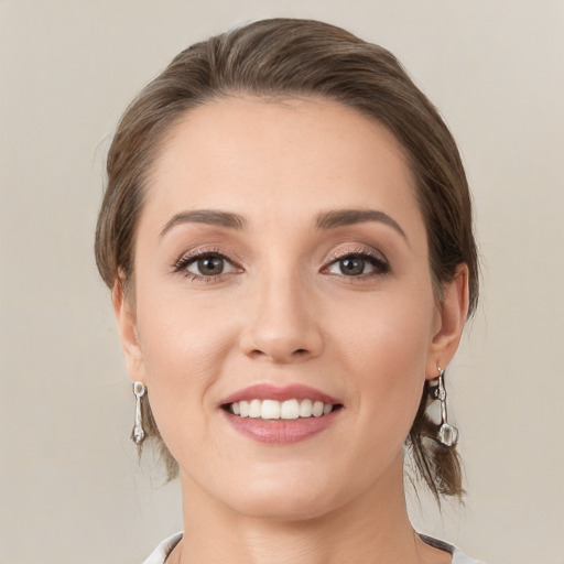 Joyful white young-adult female with medium  brown hair and grey eyes