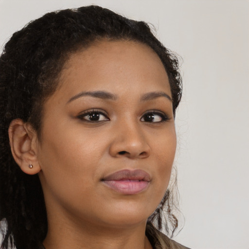 Joyful black young-adult female with long  brown hair and brown eyes