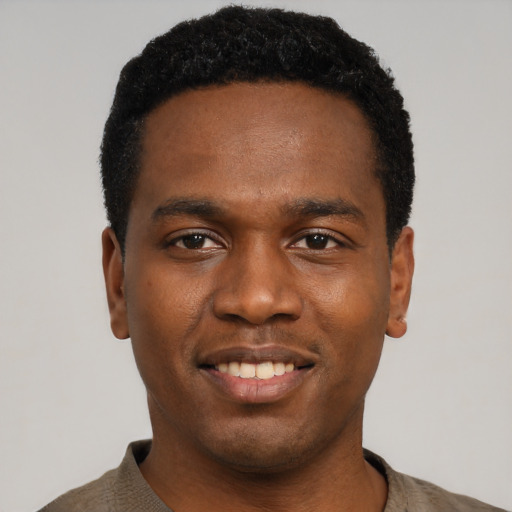 Joyful black young-adult male with short  black hair and brown eyes