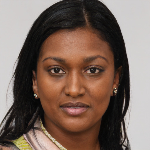 Joyful black young-adult female with long  black hair and brown eyes