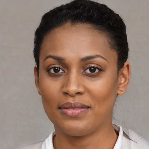 Joyful black young-adult female with short  black hair and brown eyes