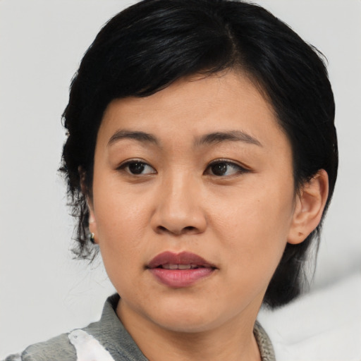 Joyful asian adult female with medium  black hair and brown eyes