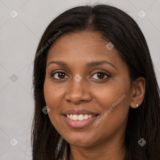 Joyful black young-adult female with long  brown hair and brown eyes