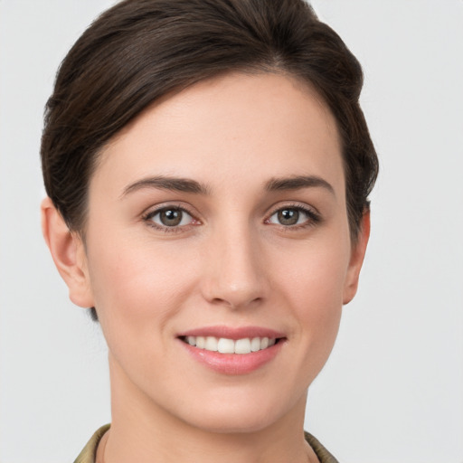 Joyful white young-adult female with short  brown hair and grey eyes