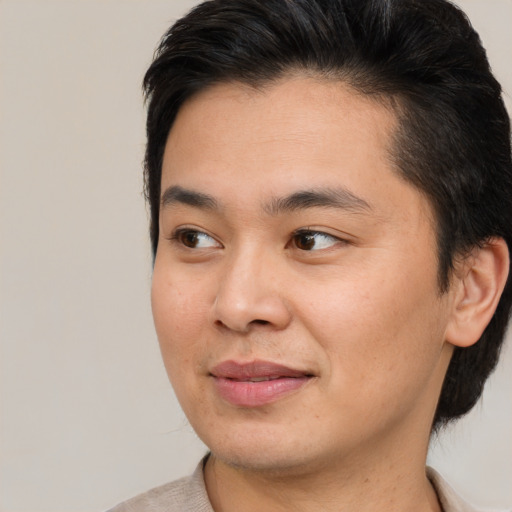 Joyful asian young-adult male with medium  brown hair and brown eyes