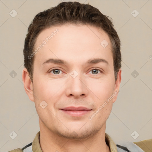 Joyful white young-adult male with short  brown hair and grey eyes