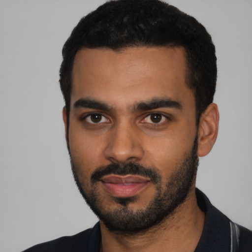 Joyful black young-adult male with short  black hair and brown eyes