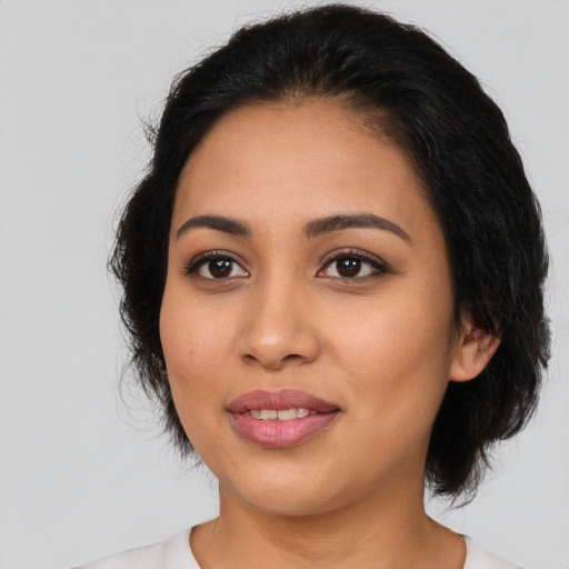 Joyful latino young-adult female with medium  black hair and brown eyes