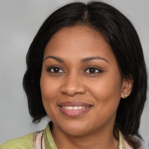 Joyful black young-adult female with medium  brown hair and brown eyes