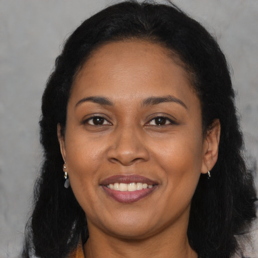 Joyful latino adult female with long  brown hair and brown eyes
