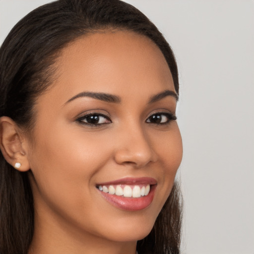 Joyful latino young-adult female with long  brown hair and brown eyes