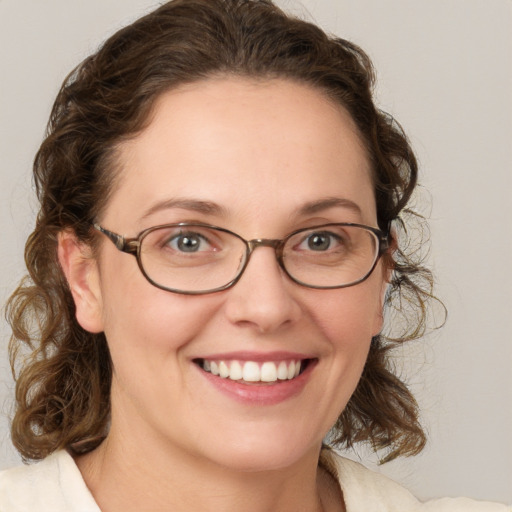 Joyful white young-adult female with medium  brown hair and green eyes