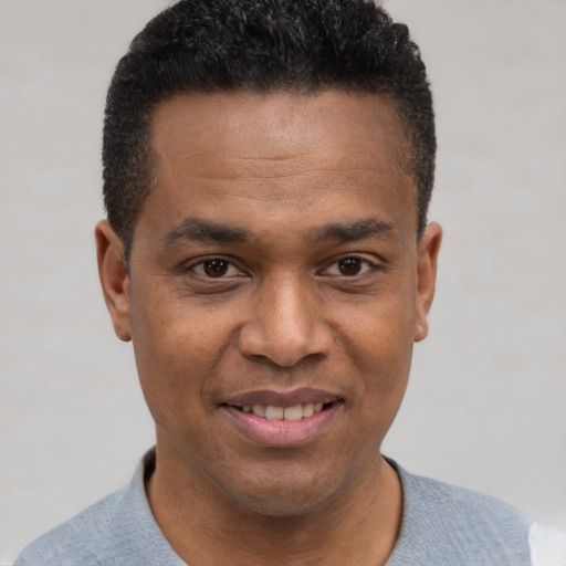 Joyful black young-adult male with short  brown hair and brown eyes