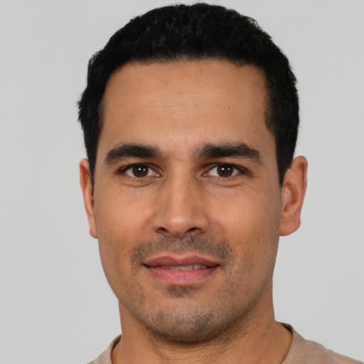 Joyful white young-adult male with short  black hair and brown eyes